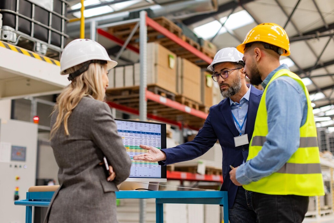 Manufacturing sales, management and operations team discussing performance on the factory floor