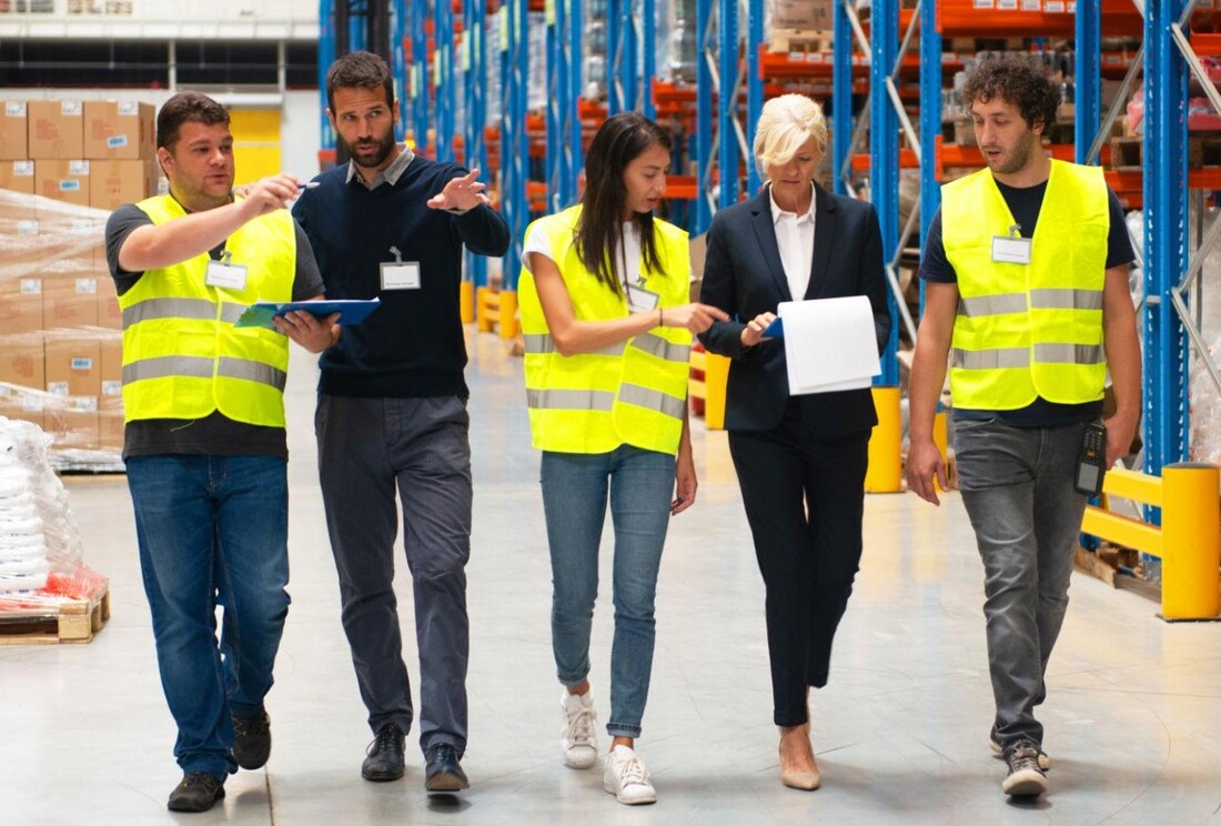 Commercial and operational team walking together through a warehouse and distribution facility.